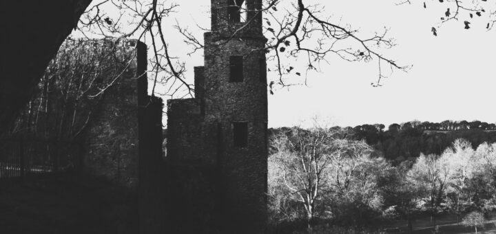 Black and White image of abandoned tower, franed with trees