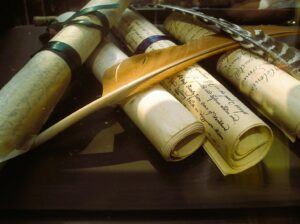 Set of scrolls on a table with a quill pen